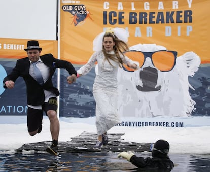 Una pareja celebra su primer aniversario saltando en un estanque helado, en Calgary (Canadá).