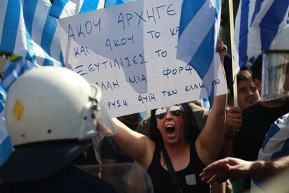 Partidarios de Aurora Dorada con un cartel que dice: "Escucha jefe, escucha de nuevo, han ridiculizado el sistema una vez más - Aurora Dorada de los griegos".