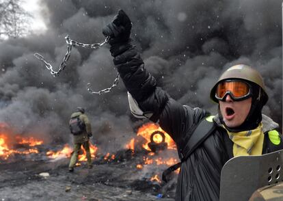 Un manifestante pro eruropeo ante barricadas ardiendo en el centro de Kiev durante los duros enfrentamientos entre policías y manifestantes.