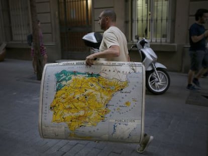 Un hombre, con un mapa de Espa&ntilde;a en el centro de Barcelona.