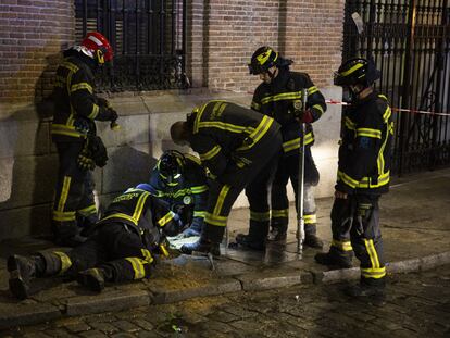 Un grupo de bomberos del Ayuntamiento de Madrid trabajan en una zona cercana al lugar donde se ha producido una explosión para cortar el agua que abastece al edificio siniestrado.