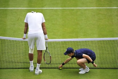 Argentina's Juan Martín del Potro reacts to netting a shot after a rally against Spain's David Ferrer as the ballboy collects a ball.