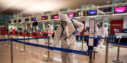 Miembros de la Unidad Militar de Emergia (UME) desinfectan el área de facturación de equipaje del aeropuerto de Barcelona-El Prat.