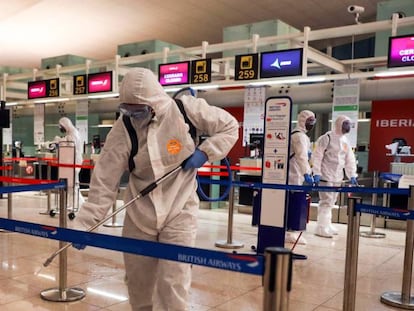 Miembros de la Unidad Militar de Emergia (UME) desinfectan el área de facturación de equipaje del aeropuerto de Barcelona-El Prat.