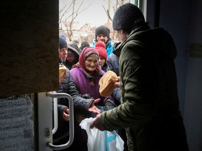 Un grupo de vecinos de Mariupol recibe ayuda humanitaria, el lunes en la ciudad ucrania asediada por las tropas rusas.