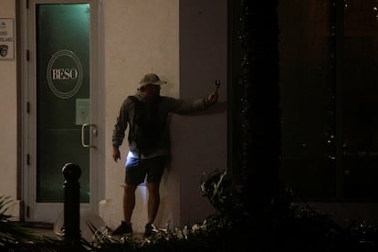 Un hombre graba mientras el huracán toca tierra, en Sarasota, Florida.