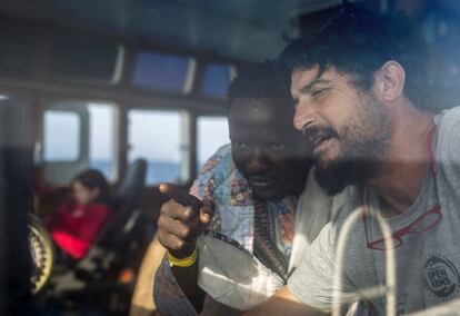 El capitán del Open Arms, Marco Martínez Esteban le enseña el control del barco a Narcisse Saturnin Gbamago, de 30 años, un migrante de República Centroafricana rescatado frente a la costa Libia, el 2 de julio de 2018.