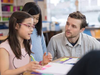 Un profesor trabaja con una estudiante de Primaria.