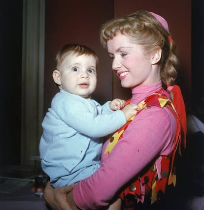 La actriz Debbie Reynolds sujeta en brazos a su hija, Carrie Fisher, en 1956.