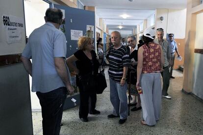 Un grupo de griegos espera antes de votar en un colegio electoral en Atenas.