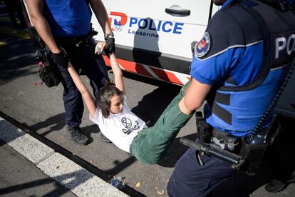 La policía expulsa a una activista de Extinction Rebellion durante la huelga convocada en Lausana (Suiza). 