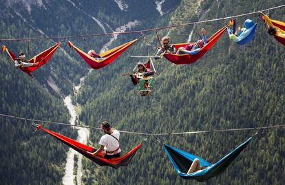 Atletas aficionados al deporte extremo descansan sobre unas hamacas a decenas de metros de altitud durante el encuentro internacional de slackline celebrado en Monte Piana, cerca de Misurina, en los Dolomitas italianos. Las vistas desde el paraje son impresionantes.