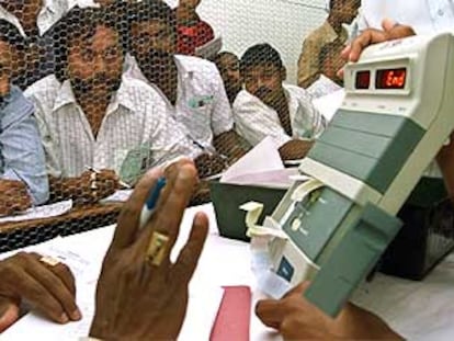 Interventores de los partidos miran una máquina electrónica de recuento de votos en la ciudad sureña de Bangalore.