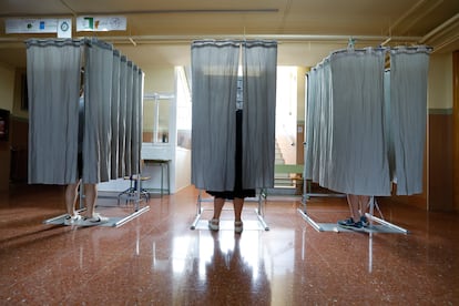 Tres votantes usan las cabinas electorales en un colegio de Granda, este 23 de julio.