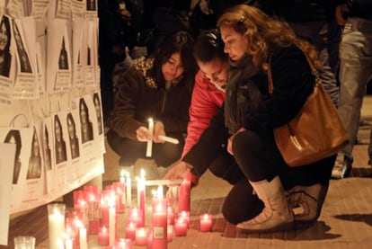 Amigos de la víctima depositan velas frente al bar de la familia de la dominicana asesinada.