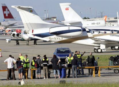 Los pasajeros del Airbus A-320 de la compañía Swiss International Airlines son registrados en la pista, tras el desalojo del avión por una amenaza de bomba.