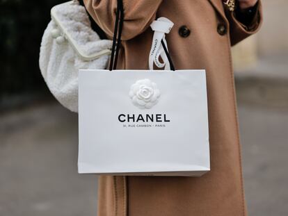 Una mujer pasea con una bolsa de Chanel, que podría revenderse en el emergente mercado de las bolsas de lujo de cartón.