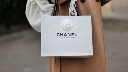 Una mujer pasea con una bolsa de Chanel, que podría revenderse en el emergente mercado de las bolsas de lujo de cartón.