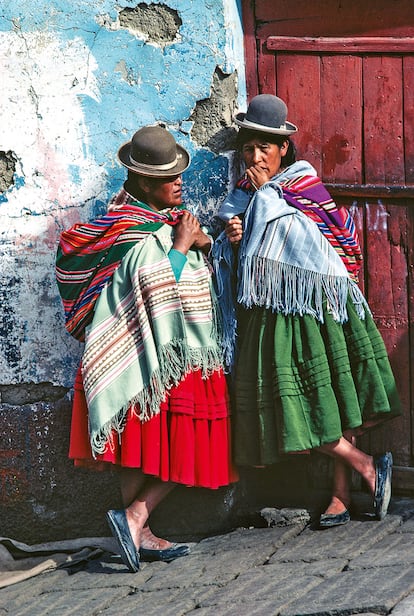 CHOLAS (BOLIVIA). Las mujeres indígenas bolivianas llevan bombines de fieltro, poncho y vestidos tradicionales (aquí en el Mercado Negro de La Paz). Las mantas de suave lana de llama o alpaca se usan, principalmente, en la capital, no así en otras zonas del país donde las temperaturas suelen ser más altas.