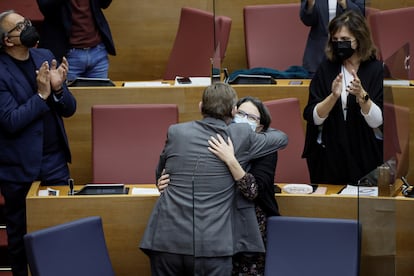 El president de la Generalitat, Ximo Puig, abraza a la vicepresidenta del Consell, Mónica Oltra, durante el pleno de Les Corts Valencianes que ha aprobado los Presupuestos de la Generalitat para 2022.