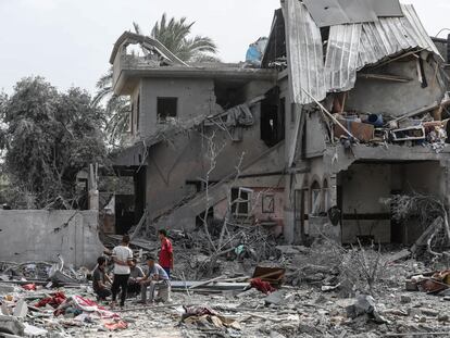 Varios palestinos junto a un edificio destrozado tras un ataque israelí, este sábado en la ciudad de Al-Zawayda, en la zona central de la franja de Gaza.