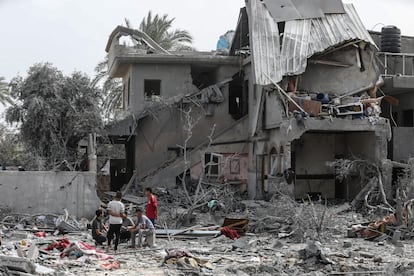 Varios palestinos junto a un edificio destrozado tras un ataque israelí, este sábado en la ciudad de Al-Zawayda, en la zona central de la franja de Gaza.