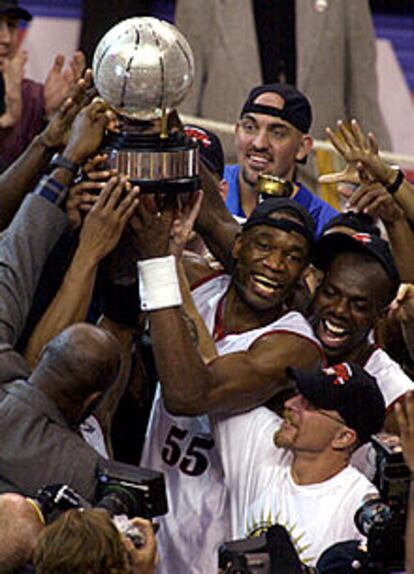 Dikembe Mutombo alza el trofeo que reconoce la victoria de su equipo en la final de la Conferencia Este.