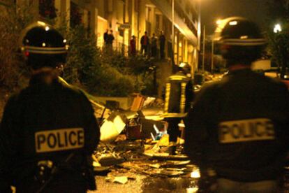 Policías franceses inspeccionan los daños causados por los disturbios en Clichy-sous-Bois el lunes.