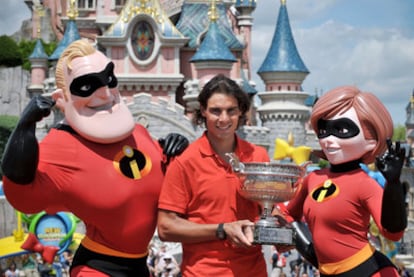 Rafael Nadal, ayer en Disneylandia, exhibe su trofeo de campeón de Roland Garros junto a los personajes de la película <i>Los increíbles.</i>