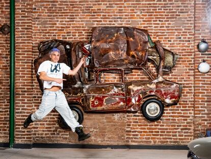 Mauro Ketlung poses with one of his sculptures.