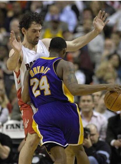 El jugador de los Raptors, Jorge Garbajosa defiende un balón ante la estrella de los Lakers de Los Ángeles, Kobe Bryant, en un partido que ganaron los de Toronto al imponerse por 96-92