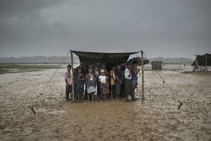 <p>Refugiados rohingya se refugian de la lluvia en el campo de Nayapara, en el distrito de Ukhia, en Bangladés, el 6 de octubre de 2017.</p> <p>El Gobierno bangladesí no les reconoce el estatus de refugiados, sino de desplazados temporales. Esto hace que no se puedan construir estructuras permanentes para que se instalen.</p>