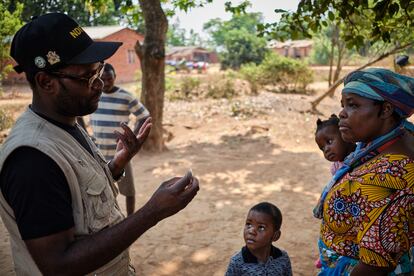 Durante una visita a una aldea en el sur de Malaui llamada Naluso, el Comisionado del Distrito de Mulanje, Stillinchi Mwambiwa, vacuna a los hijos de Naomi Phiri (a la derecha). Mwambiwa dice que quiere ser un ejemplo de liderazgo y va a las comunidades para solucionar el problema del rechazo a la inmunización.