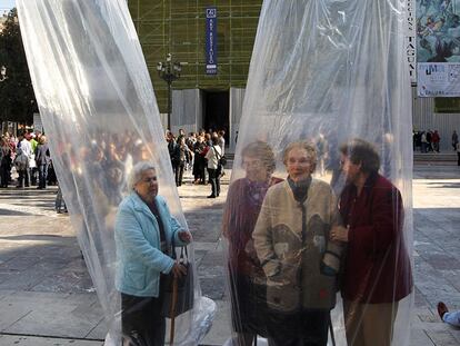 Mujeres enfundadas en dos preservativos gigantes celebran el Día Mundial del Sida, en la Plaza de la Virgen (Valencia).