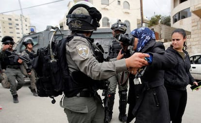 Una fotógrafa local toma fotos mientras un miembro de la policía fronteriza israelí la detiene durante la demolición de una casa palestina que no había obtenido una licencia de construcción en Beit Jala, en el oeste ocupado por Israel.