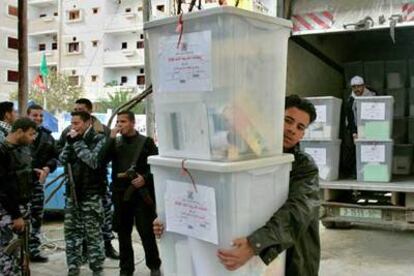Policías palestinos presencian la descarga de urnas ayer en Gaza.