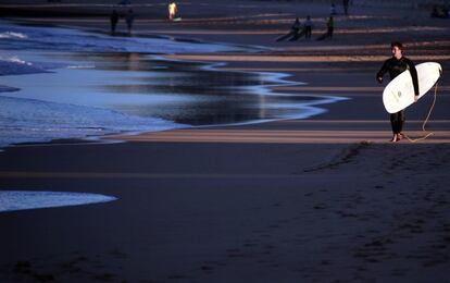 Un surfista caminando a lo largo dela playa de Manly, en Sidney, Australia. La Oficina de Meteorología australiana dijo que Sidney está experimentando una racha récord de días de otoño consecutivos por encima de los 20 grados Celsius (68 grados Fahrenheit), rompiendo el récord anterior de 25 días establecido en 1987.