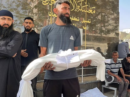 Un palestino sostiene el cuerpo de un familiar en Gaza, este lunes.