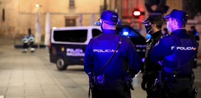 Tres policías nacionales trabajan en Salamanca, la noche en la que la ciudad ha vivido su primer toque de queda dictado por la Junta de Castilla y León.