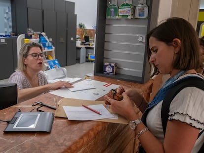 Una mujer deposita su voto en la oficina central de Correos en Sevilla, este jueves.