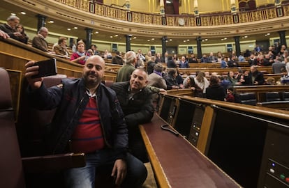 Unos visitantes se hacen un selfie entre los escaños de los diputados en el Congreso de los Diputados.