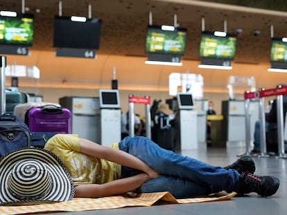 Un pasajero de Viva Air duerme en el piso del aeropuerto El Dorado en Bogotá, el pasado 29 de febrero.