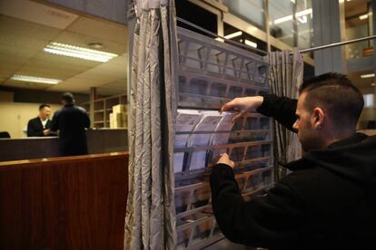 Un funcionario prepara las papeletas en una cabina en el Ayuntamiento de Barcelona.