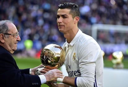 Cristiano Ronaldo recibe de la mando de Francisco Gento, presidente de honor del Real Madrid, el Balón de Oro antes del comienzo del partido contra el Granada. 