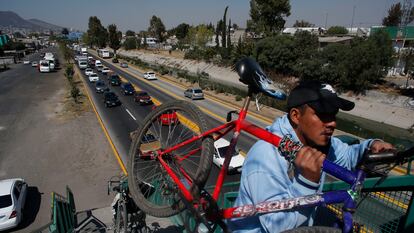 Hombres cargan sus bicicletas para cruzar un puente peatonal en Ecatepec, en febrero de 2016.