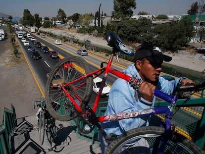 Hombres cargan sus bicicletas para cruzar un puente peatonal en Ecatepec, en febrero de 2016.