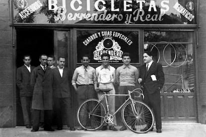 La inauguración de la tienda de bicicletas 'Berrendero y Real'. Julián Berrendero, el quinto de izquierda a derecha, agarra el sillín. /PÁGINA DE FACEBOOK DEDICADA AL CICLISTA