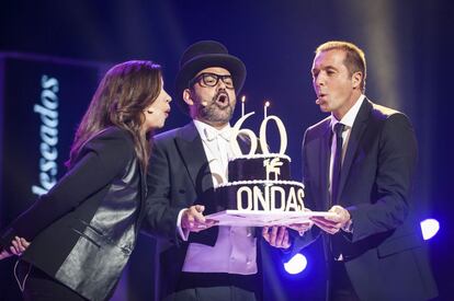 Ángels Barceló, Corbacho y Manu Carreño soplan las velas de la tarta conmemorativa del 60º aniversario de los Premios Ondas .