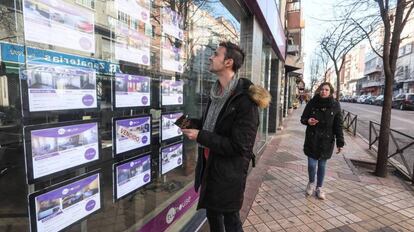 Un joven observa la oferta de pisos de una inmobiliaria en Madrid.