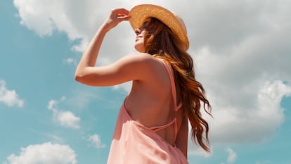 Chica tomando en sol con un sombrero.